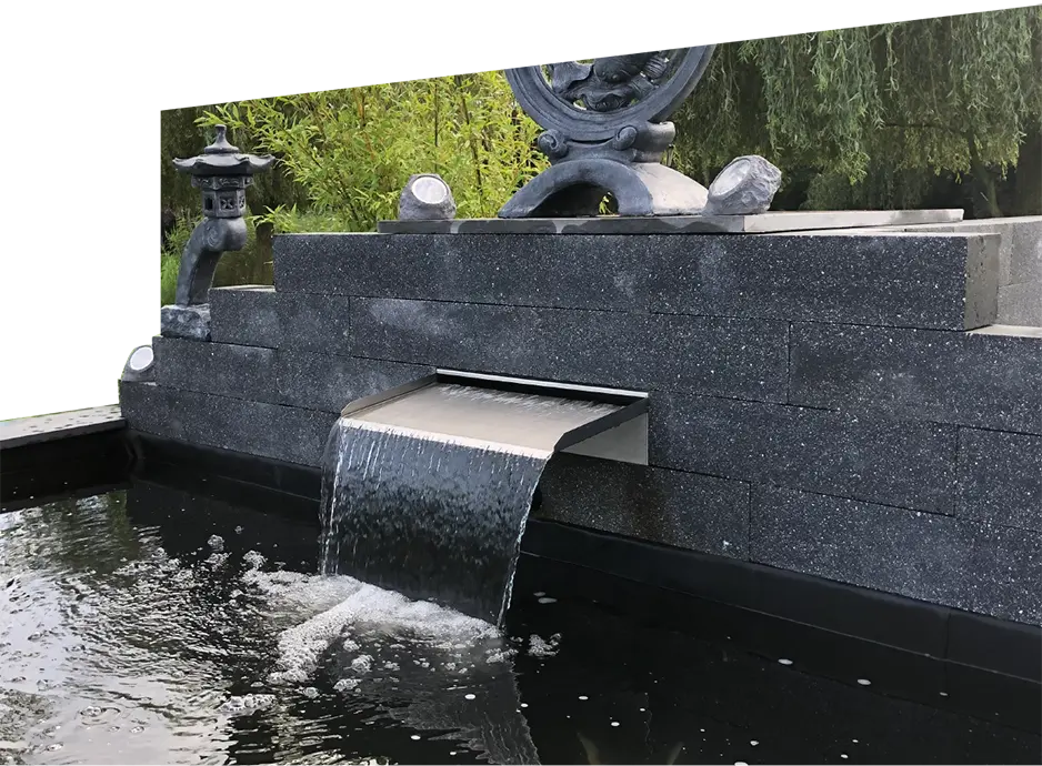 Rechteckiger Edelstahl Einbau-Wasserfall vom Typ Livingstone, eingebaut in eine moderne Teichwand aus dunklem Stein