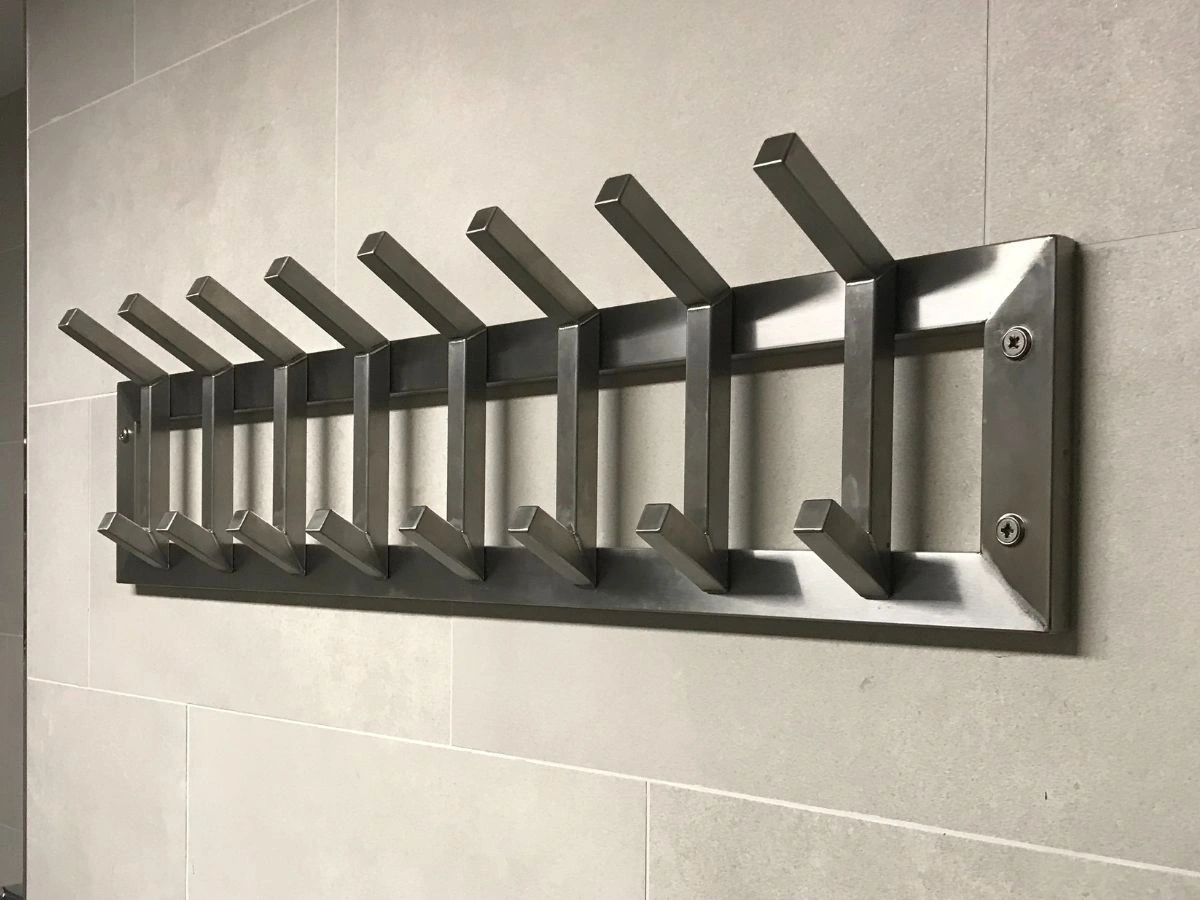 Minimalistische Edelstahl-Garderobe nur mit Haken – platzsparend montiert im Bad oder Flur.