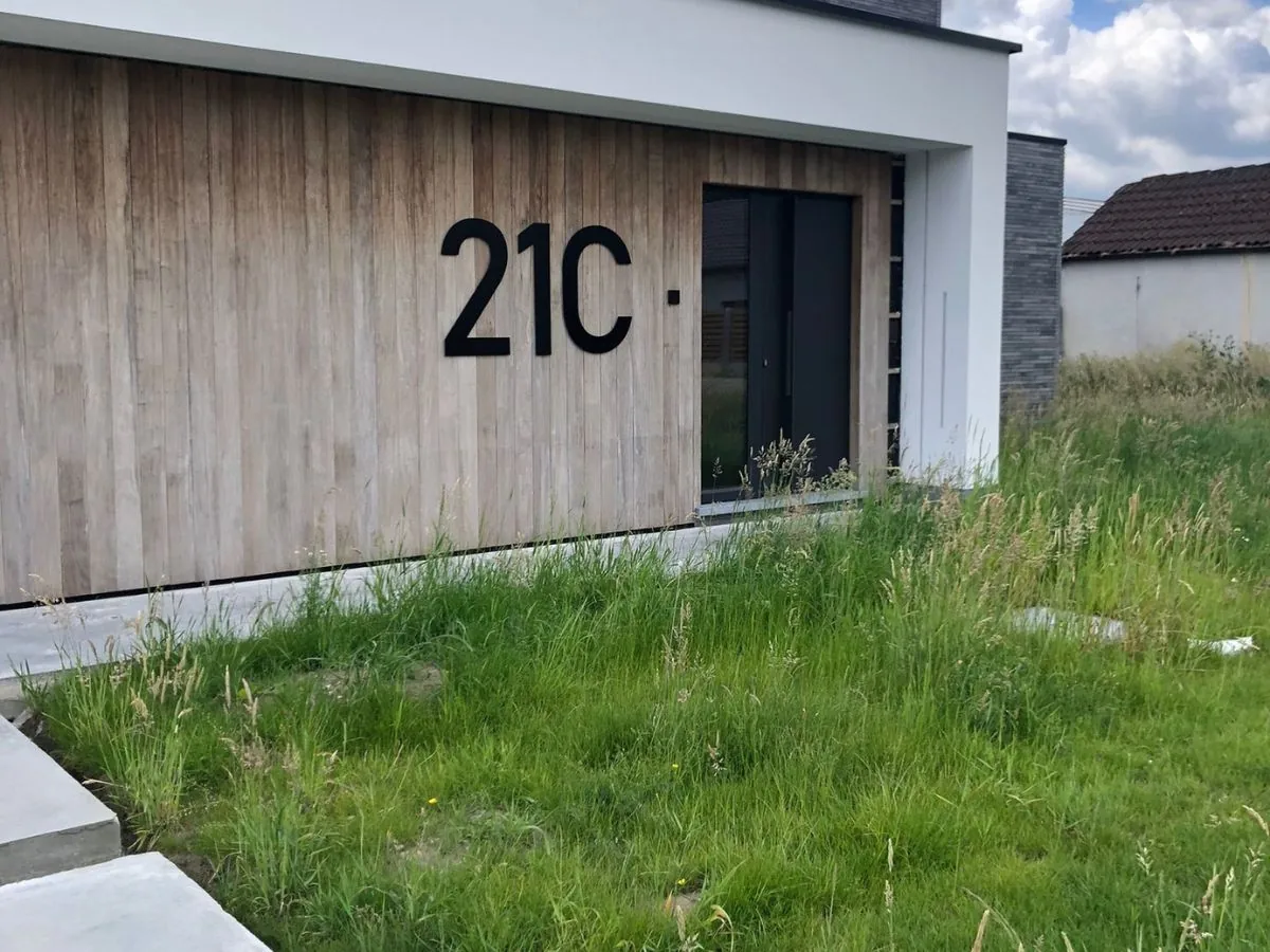 Schwarze Edelstahl Hausnummer 21C auf Holzverkleidung – klare Lesbarkeit und Kontrast