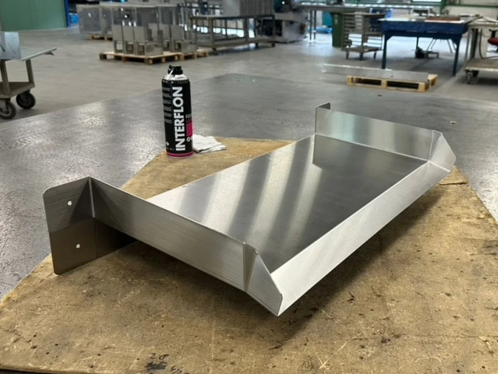 Überlauf-Wasserfall aus Edelstahl in der Werkstatt, vorbereitet mit Interflon Food Lube zur Pflege und Schutzbehandlung der Oberfläche