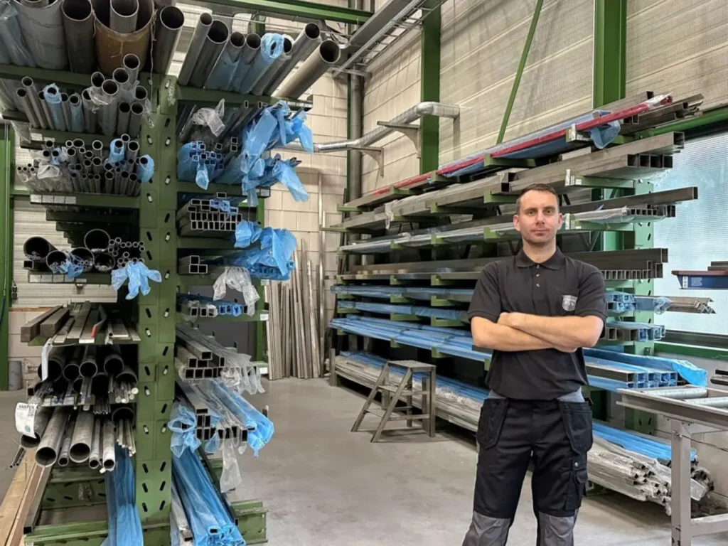 Mitarbeiter von Custom RVS in der Edelstahl-Werkstatt zwischen gelagerten Profilen