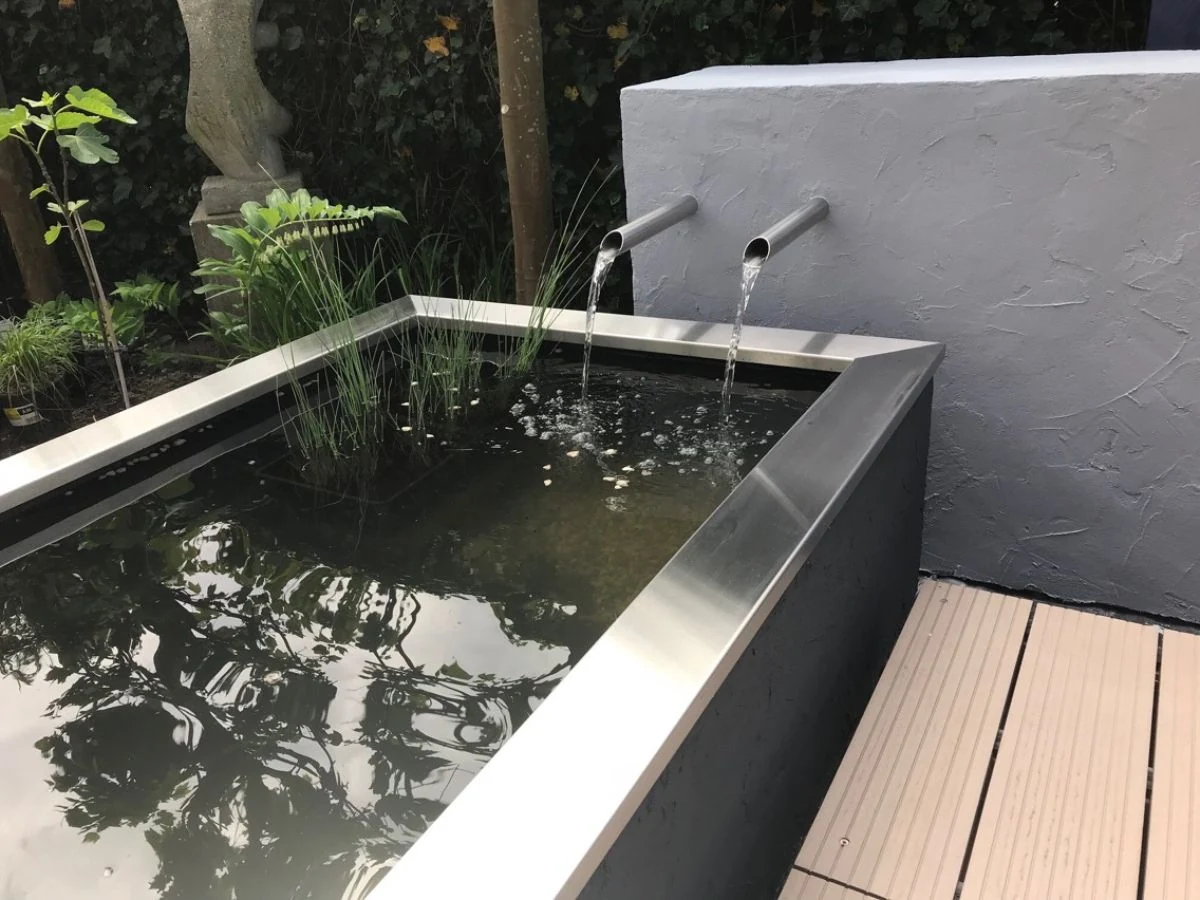 Zwei gerade Edelstahl-Wasserausläufe aus Edelstahl 304 in moderner Teichumrandung mit klarem Wasserfluss